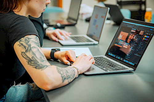 Tým s otevřenými notebooky v zasedací místnosti