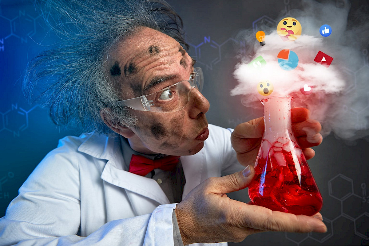 Vědec s kádinkou vytvářející emoce v podobě emotikonů